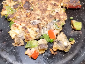 Untitled egg recipe cooked with spring onion, tomato, mushrooms and feta cheese